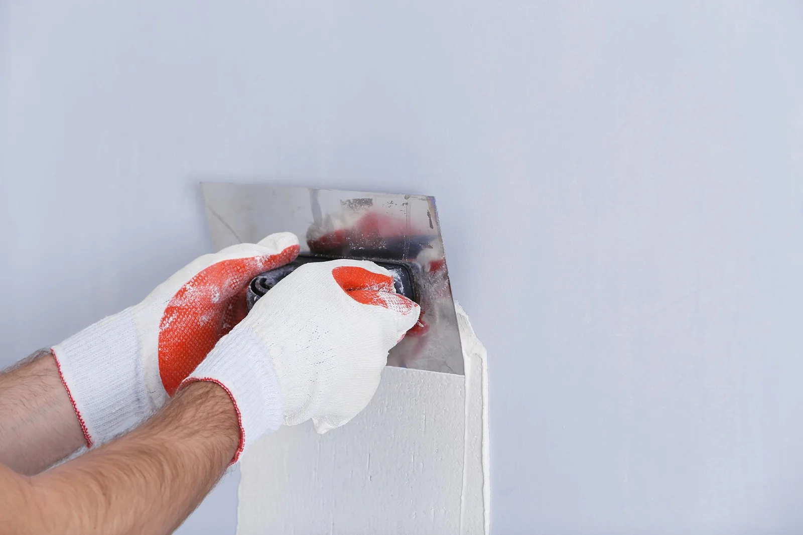 Painter’s hand doing drywall repair Everett for smooth wall preparation before painting