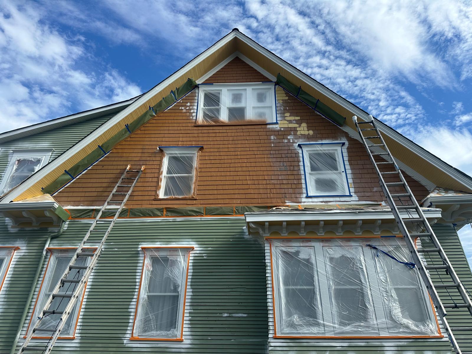 House exterior mid-painting process by Art of Painting Custom Restoration LLC, part of early booking painting discount in Everett WA.